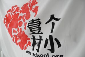印着壹个村小红色手印标志的白色横幅
